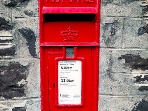 Red post box in wall : Onestop Numberplates Supplemental Postage Fees